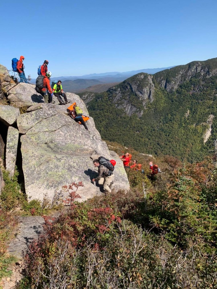 NH Fish and Game Conservation Officers, Mountain Rescue Service members and Pemi Valley Search and Rescue Team members look for a fallen climber in Franconia, N.H., on Sept. 21, 2020.