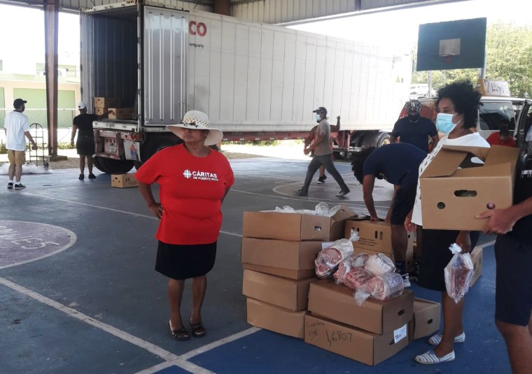Volunteers unload boxes of food donations in Loiza, Puerto Rico.
