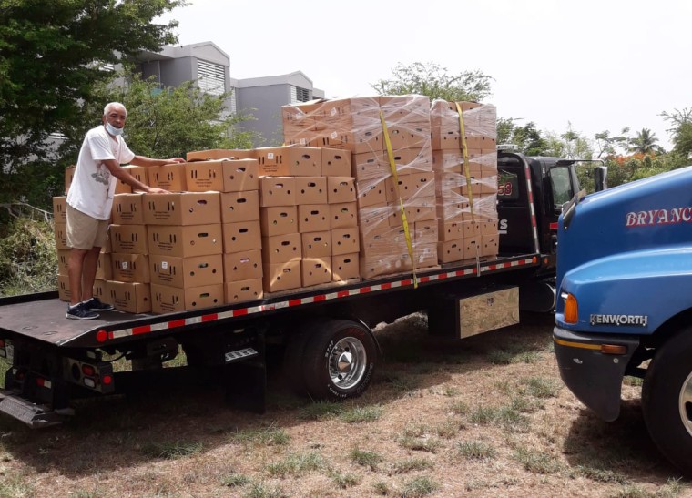 A volunteer helps unload boxes of food donations in Loiza, Puerto Rico.