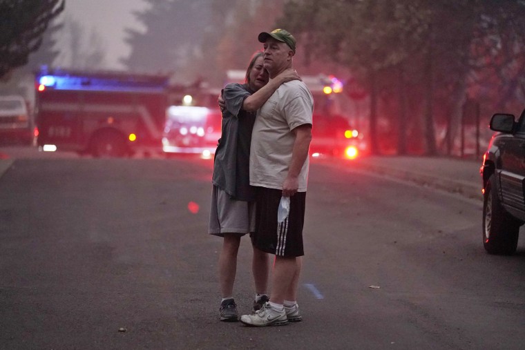 A couple embrace while touring an area devastated by the Almeda Fire on Sept. 10, 2020, in Phoenix, Ore.