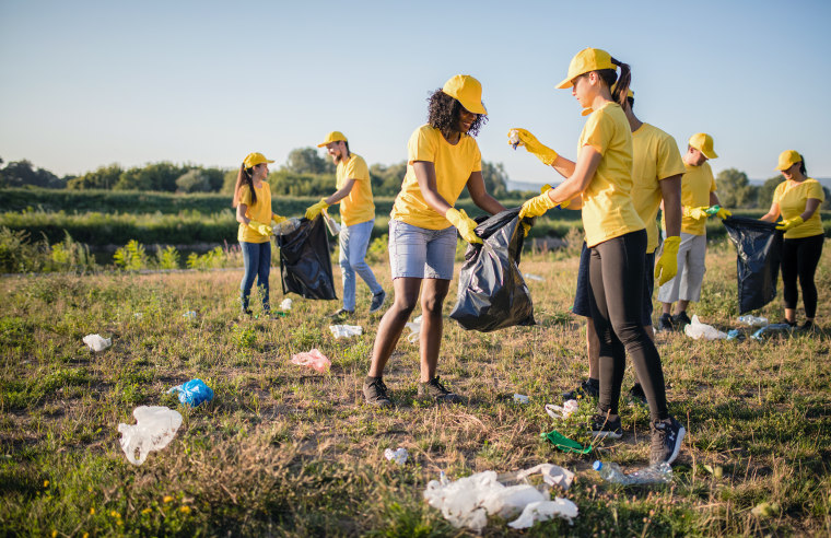 Volunteer together pick up trash in the park