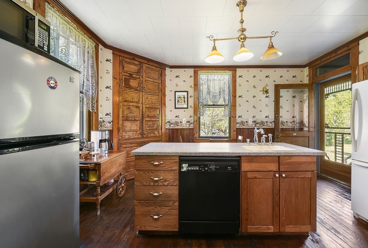 The kitchen has some new appliances but also features original woodwork and wallpaper. 