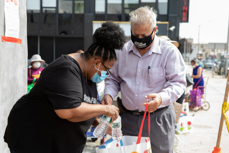 Ana, with her father-in-law Jose, at a food pantry in Hempstead, New York. Ana is a paraprofessional educator who hasn't worked since March and her husband works as a clerk in a hospital, a job that has been especially stressful during the COVID-19 crisis.