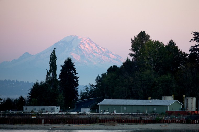 Image: Mount Ranier sits behind the Wyckoff/Eagle Harbor Superfund site on Bainbridge Island, Wash., on Oct. 6, 2020. The soil and groundwater beneath the area is contaminated by toxins from a wood-treatment facility that ran off-shore for 85 years. The E