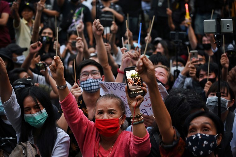 Image: Protesters hold wands in the air during a Harry Potter-themed anti-government rally at the Democracy Monument in Bangkok