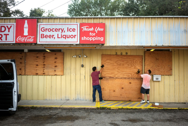 Image: Duy Dang helps his uncle Bang Bui board up his business Handy Mart as Hurricane Delta approaches in Abbeville, Louisiana.
