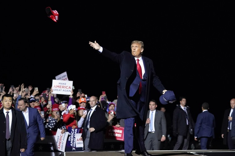 Image: President Donald Trump throws hats to supporters after speaking at a campaign rally at Duluth International Airport