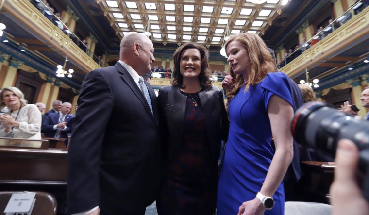 Michigan Gov. Gretchen Whitmer, center, is escorted by state Rep. Frank Liberati, left, and state Sen. Mallory McMorrow before delivering her State of the State address on  Jan. 29, 2020, at the state Capitol in Lansing.