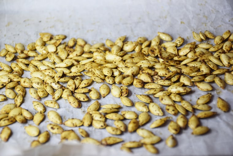 Roasted pumpkin seeds will turn golden brown. They smell like popcorn coming out of the oven!