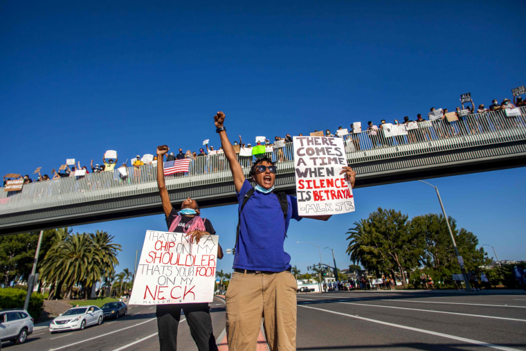 Image: Protesters hold signs during a demonstration over the death of George Floyd in Newport Beach, Calif., on June 3, 2020.