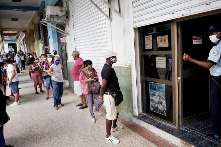 Image: FILE PHOTO: People wait in line to enter a currency exchange office in Havana, Cuba