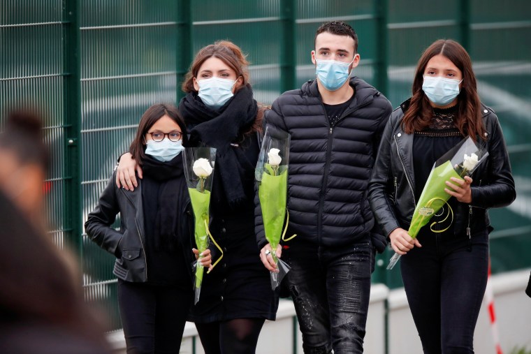 Image: People bring flowers to the Bois d'Aulne college after the attack in the Paris suburb of Conflans St Honorine