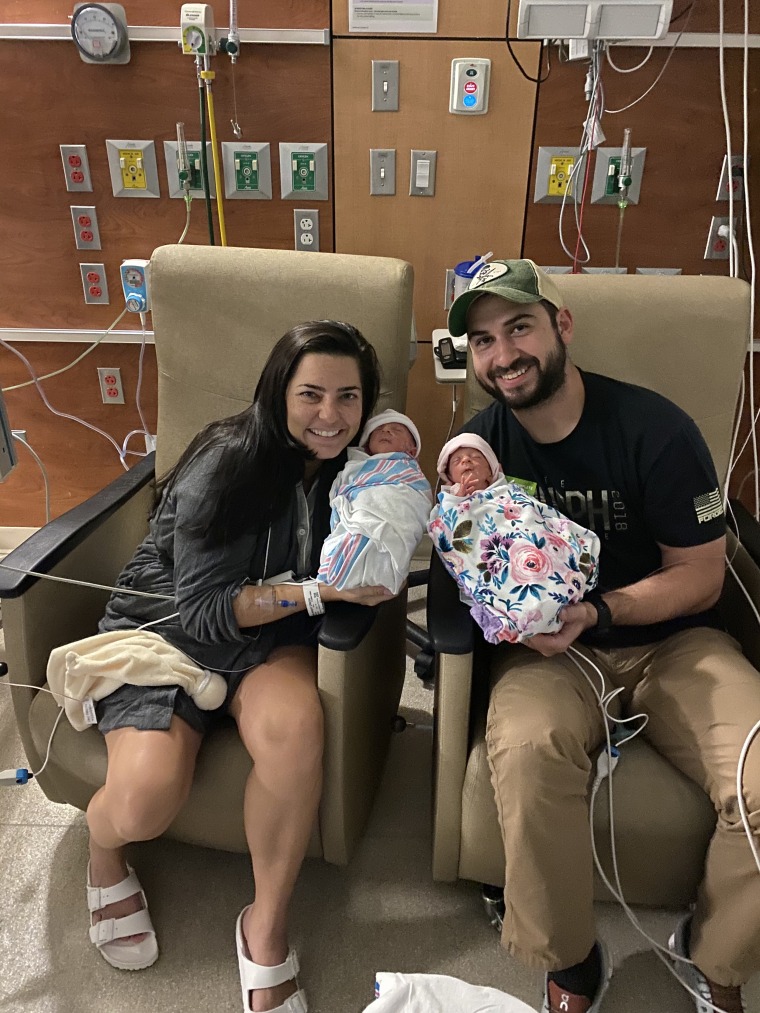 Erin and Jake Credo cuddled up with their identical twin daughters, Lola and Allie. 