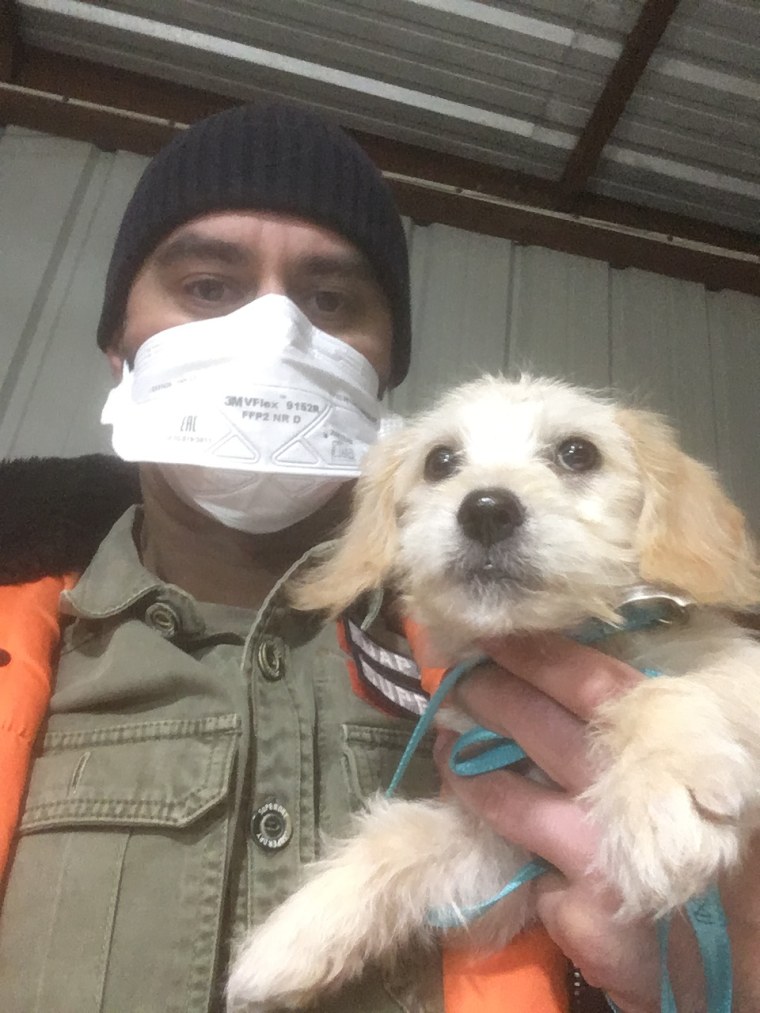Eduard Seitan wears a mask and holds a dog.