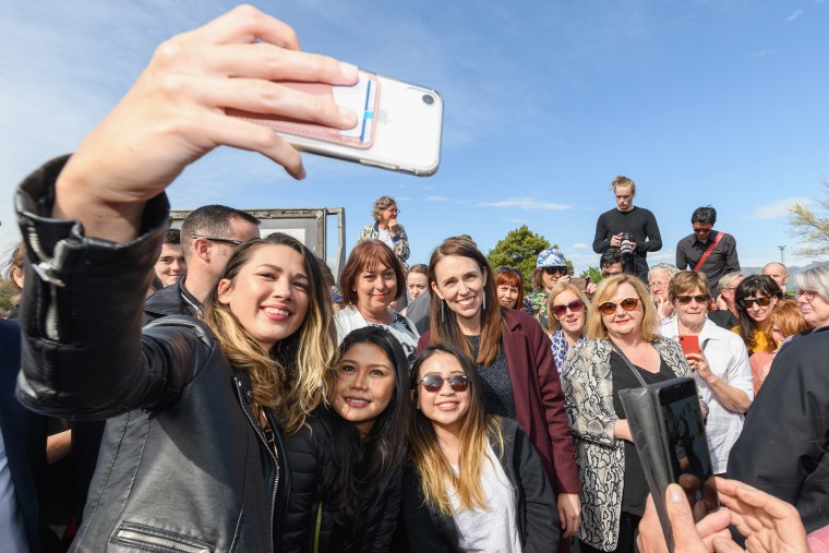 Image: Prime Minister Jacinda Ardern poses for a selfie with members of the public during a walkabout at London Street