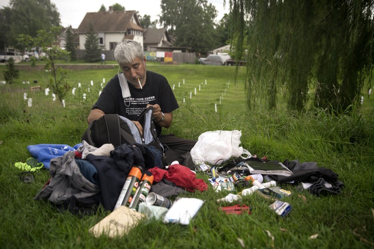 Patrick Berry, 41, packs his belongings into a bag at the "Say Their Names" memorial in Minneapolis on Aug. 16. 