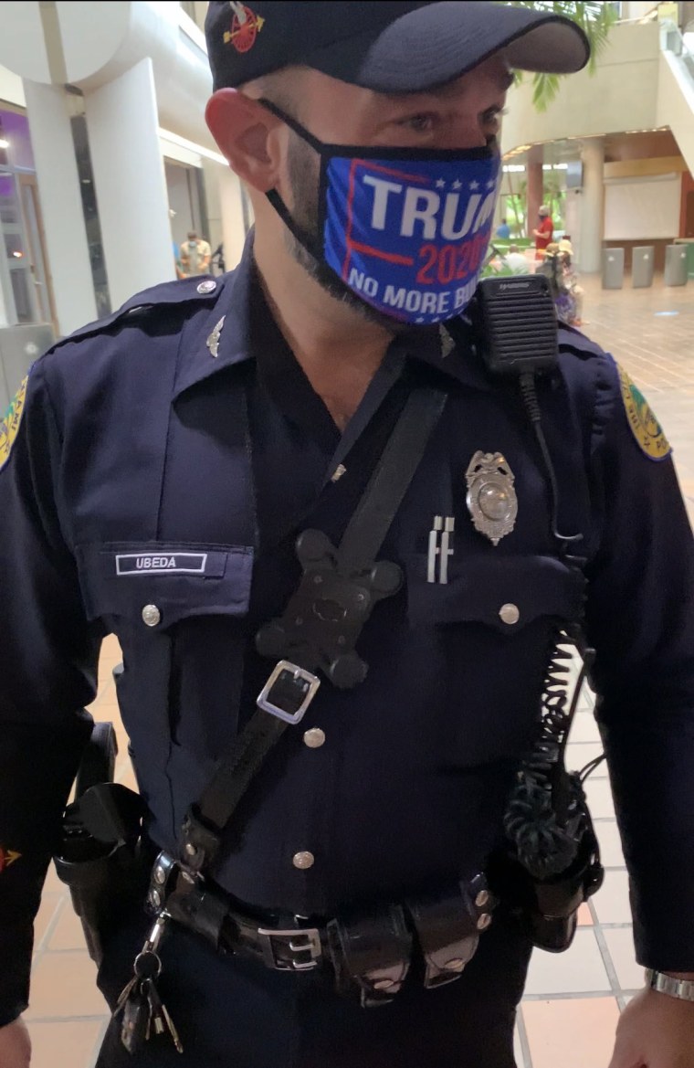A Miami police officer wearing a Trump campaign mask.