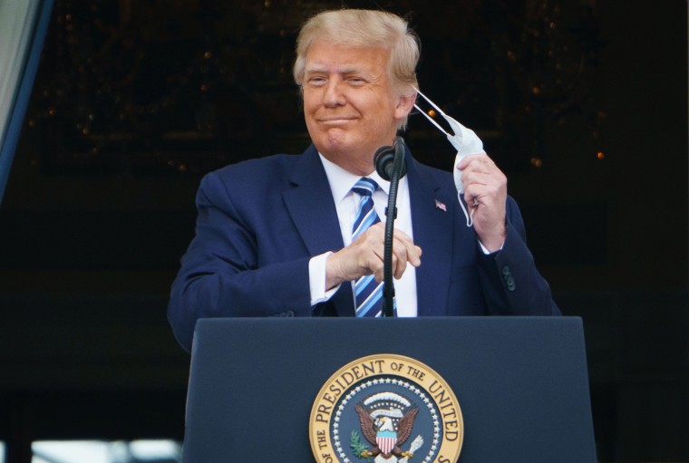 Image: President Donald Trump takes his mask off before speaking from the South Portico of the White House.