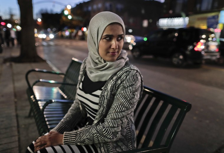 IMage: Enas Almadhwahi, an immigration outreach organizer for the Arab American Association of New York, sits for a photo along Fifth Avenue in the Bay Ridge neighborhood of Brooklyn.