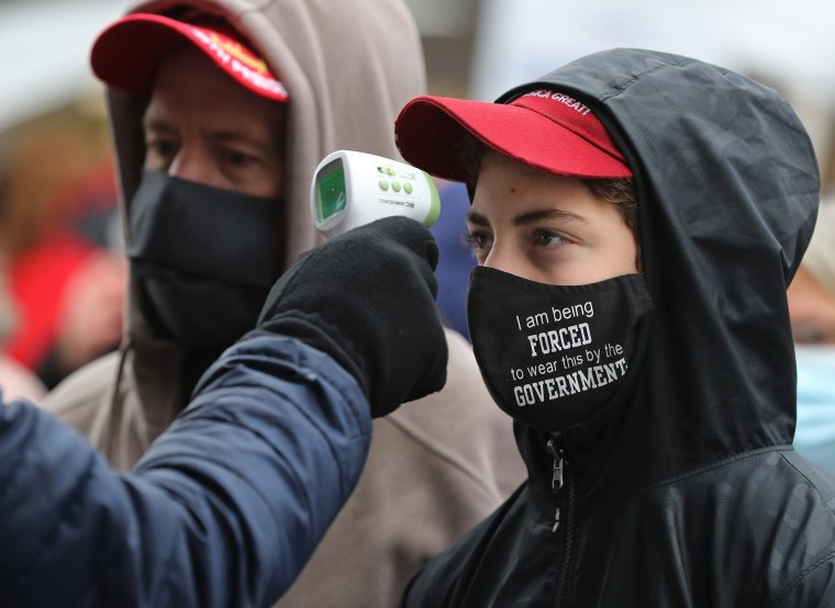 Supporters of President Donald Trump have their temperature taken before attending a campaign rally on Oct. 27, 2020 in Lansing, Mich.