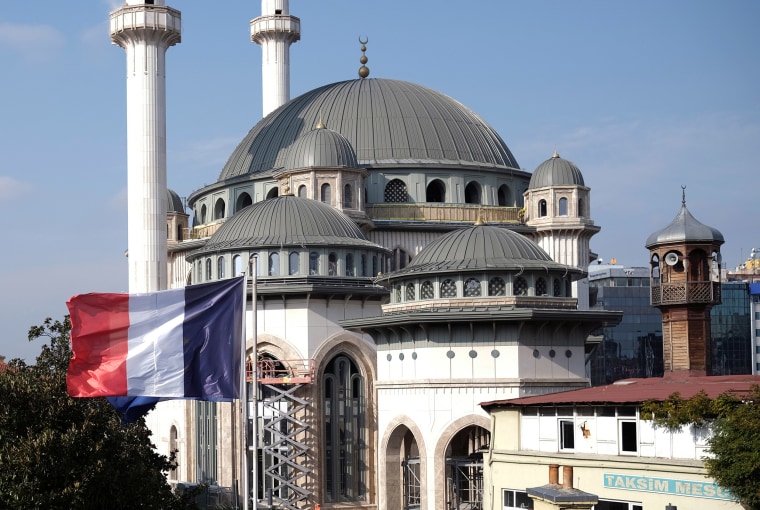 Image: A French flag flutters above the French Consulate, with a new mosque under construction in the background, in central Istanbul,