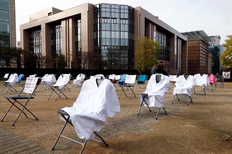 Image: Nurses' uniforms are displayed in Brussels during a symbolic action by an organization representing Europe's health and social service workers.