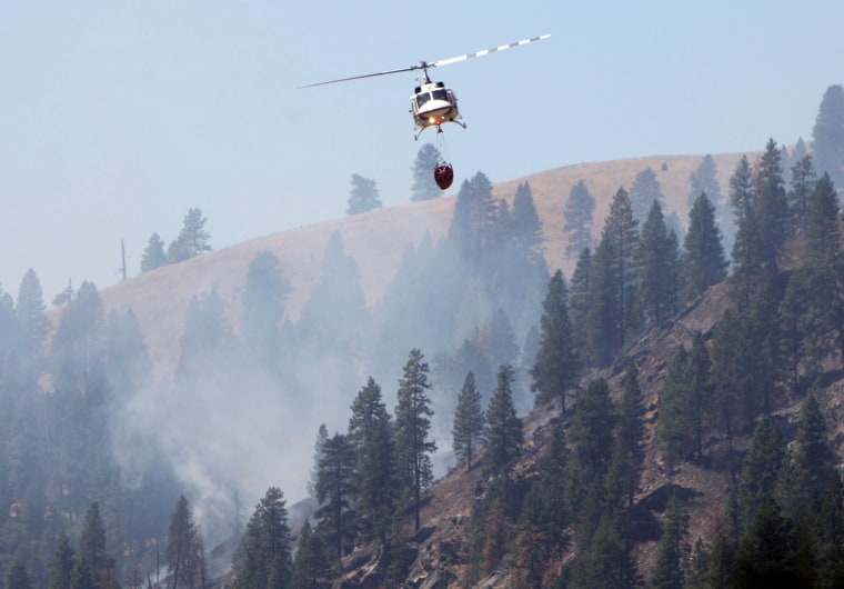 A forest service helicopter returns to the south fork of the Payette River on Aug. 6, 2012, after dropping water on the Springs Fire, east of Banks, Idaho.