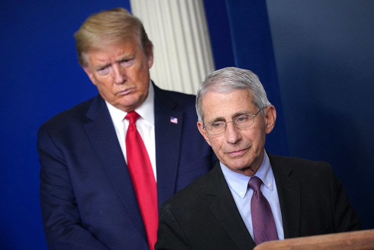 Image: Director of the National Institute of Allergy and Infectious Diseases Anthony Fauci, flanked by President Donald Trump, speaks during the daily briefing at the White House.