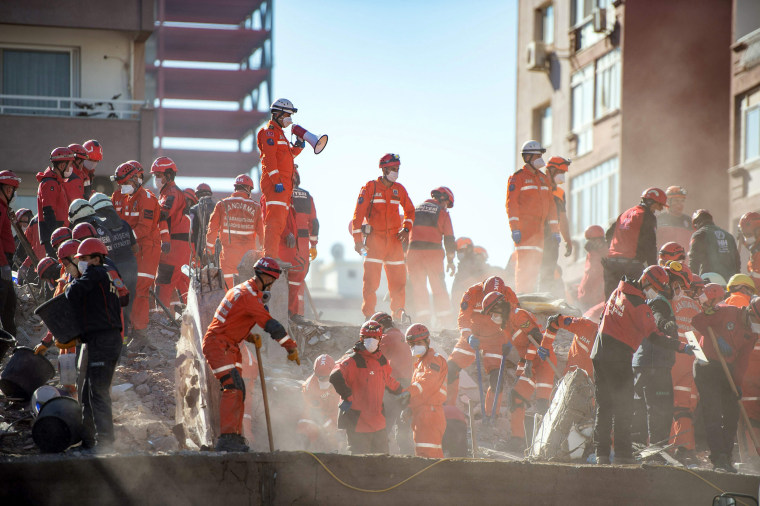 Image: Rescuers work during the ongoing search operation at the site of a collapsed building as they look for survivors and victims in the city of Izmir