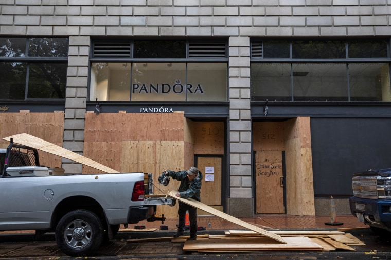 Construction crews board up shop windows in downtown Portland, Ore., on Election Day.
