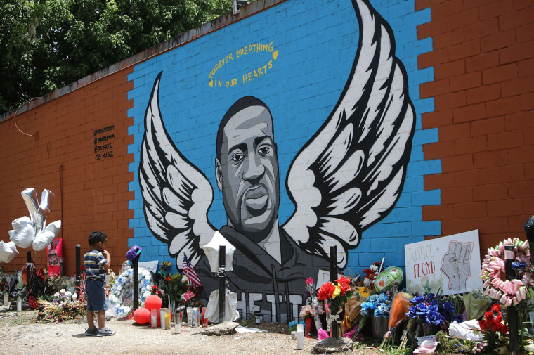 Image: A child views a mural dedicated to George Floyd, across the street from the Cuney Homes housing project in Houston's Third Ward