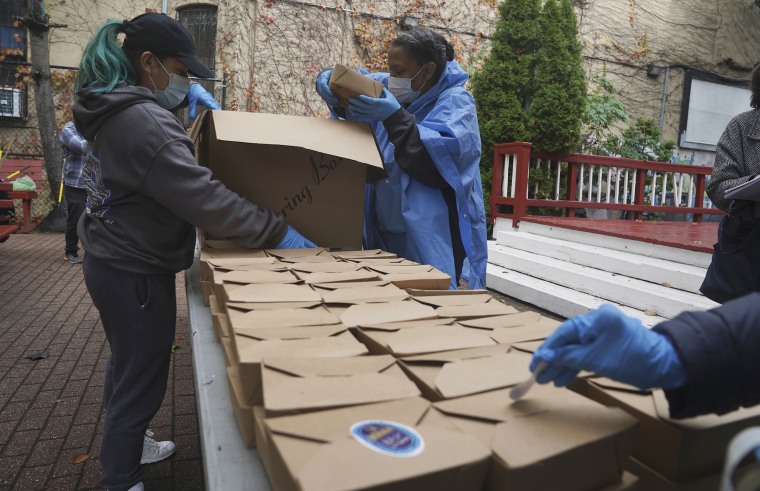Volunteers unload boxed meals prepared at the South Bronx restaurant La Morada, Oct. 28, 2020, in New York. After a fund raising campaign during the coronavirus pandemic, La Morada, an award winning Mexican restaurant, was reopened and now also functions as a soup kitchen, serving 650 meals daily.