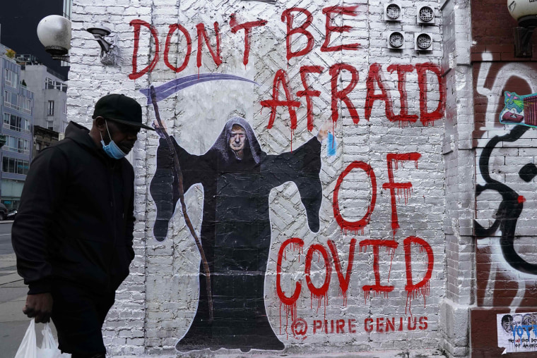 Image: A man walks past a mural by the artist who goes by the name \"Pure Genius\" depicting US President Donald Trump as the Grim Reaper on a wall on Houston Street in New York City