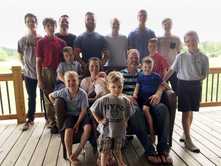 The Schwandt family poses for a photo at their farm in Lakeview, Mich., on May 30, 2018. Standing from left are Tommy, Calvin, Drew, Tyler, Zach, Brandon, Gabe, Vinny and Wesley. Seated, starting at upper left are Charlie, Luke, mother Kateri holding Finley, father Jay, with Tucker and Francisco in the foreground.