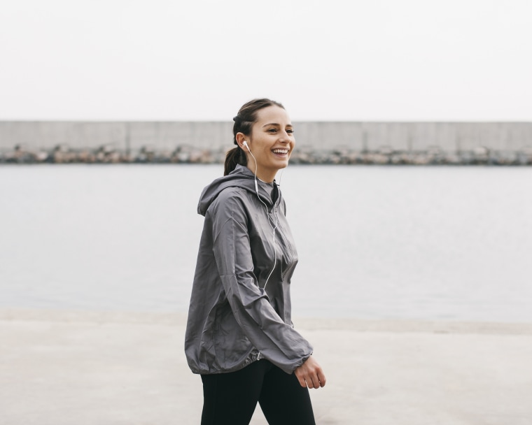 Image: Spain, Barcelona, jogging woman with headphones at harbour
