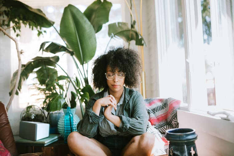 Young Woman Praying or Meditating in Home