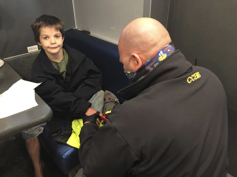 Image: 9-year-old Jordan Gorman is checked out by a Tennessee Bureau of Investigation employee after he was found in the woods near his home