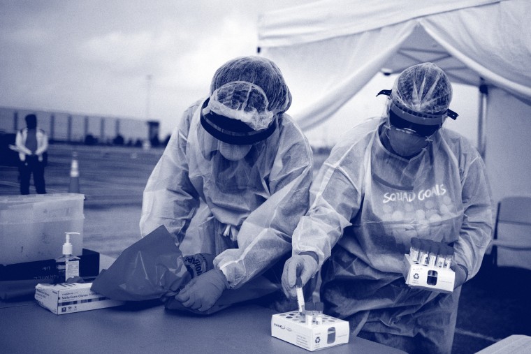 Image: Healthcare workers prepare specimen collection tubes at a coronavirus disease (COVID-19) drive-thru testing location in Houston