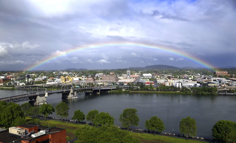 A rainbow pops out under dark rain clouds over the Willamette River in downtown Portland, Ore., on May 11, 2017.