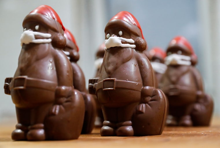 Image: Chocolate Santas wearing protective face masks are seen in the workshop of the Hungarian confectioner Rimoczi in Lajosmizse