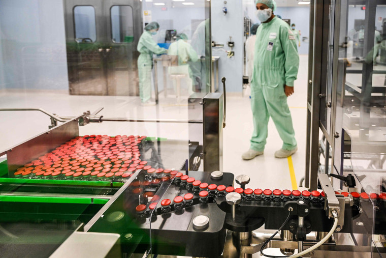 Image: A laboratory technician supervises capped vials during filling and packaging tests for the large-scale production and supply of the University of Oxfords COVID-19 vaccine candidate.