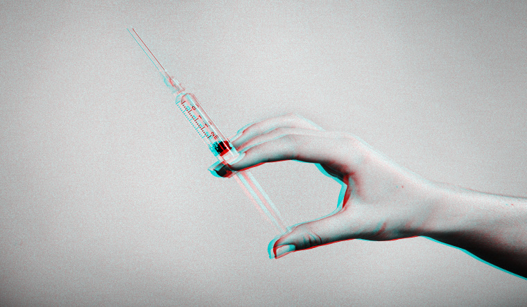 Image; Hand holding syringe in TikTok colors.