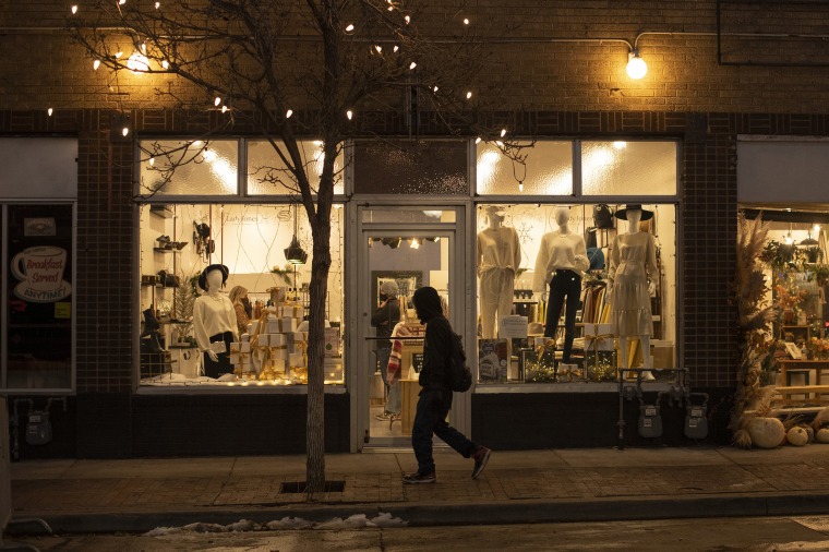 Image: A person walks by shops on Tennyson Street, in Denver