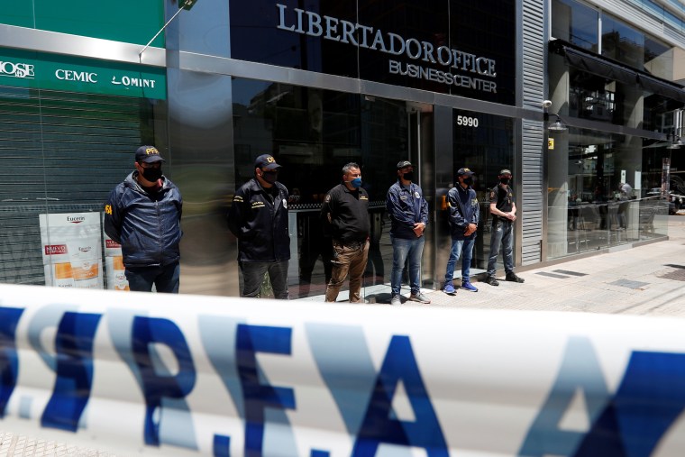 Image: Police officers stand guard outside the building where Dr. Luque has his office in Buenos Aires