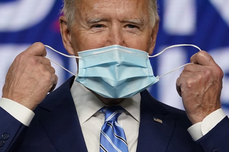 Image: Democratic presidential candidate Joe Biden takes off his face mask as he arrives to speak, Wednesday, Nov. 4, 2020, in Wilmington, Del.