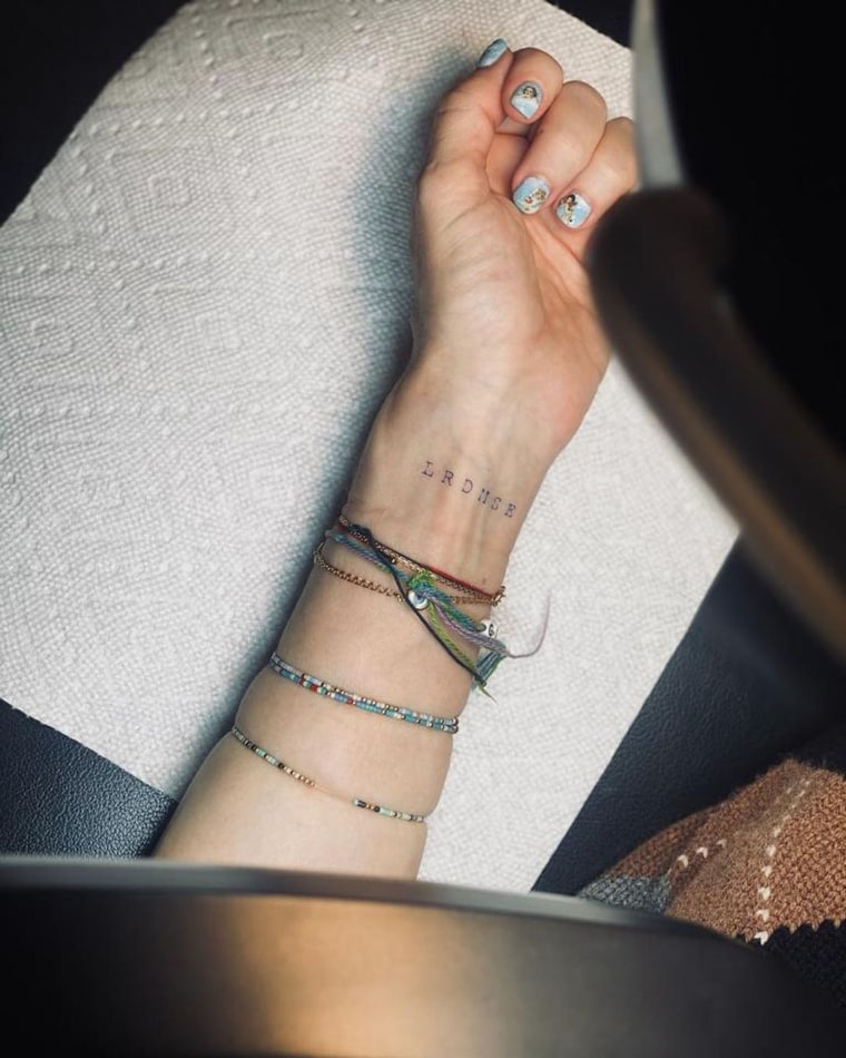The simple tattoo spells out the initials of her children.