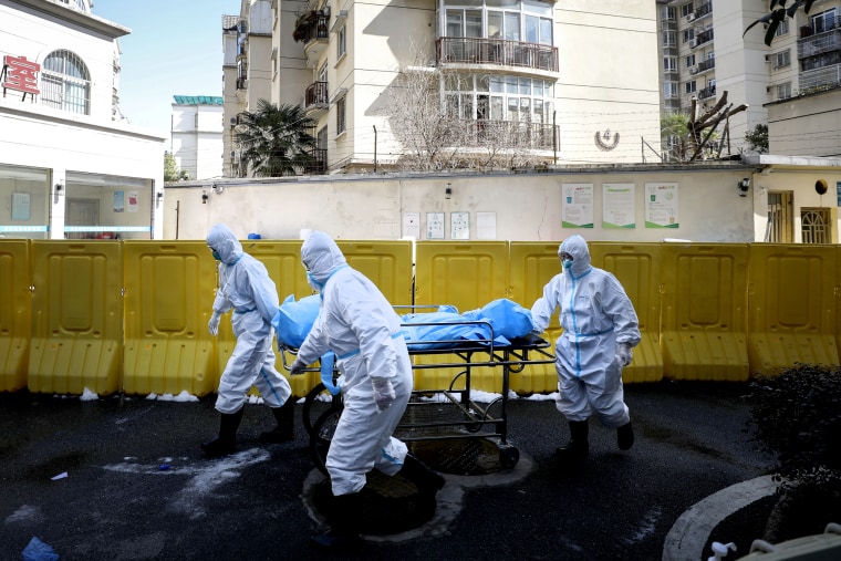 Image: Medical workers move a person who died from coronavirus at a hospital in Wuhan, China, on Feb. 16, 2020.