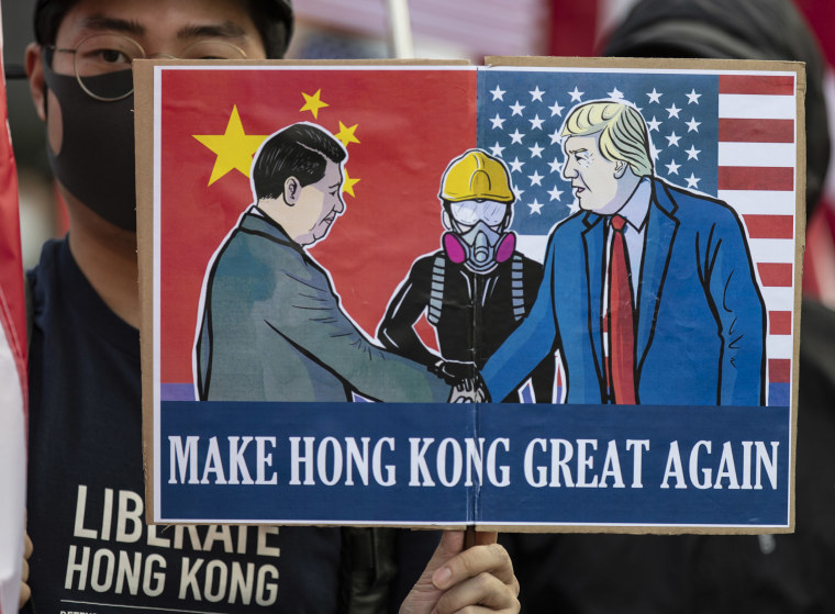 Image: A pro-democracy protester holds a placard saying, "Make Hong Kong Great Again" during a demonstration in January.