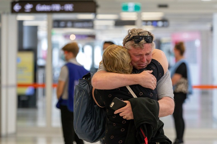 Image: A passenger is greeted after arriving from Sydney at Perth Domestic Airport following the state of Western Australia's loosening of borders on Tuesday