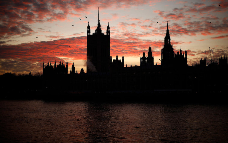Image: The sun sets behind the Victoria Tower at the Palace of Westminster, home to the Houses of Parliament, in London
